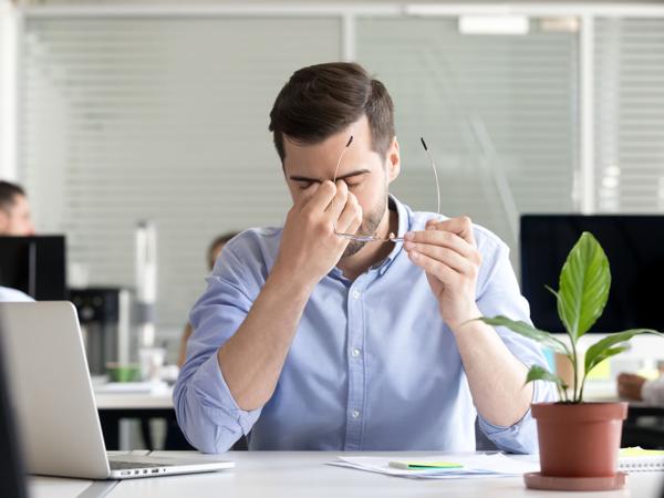 Tired businessman with eye strain