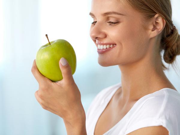 Woman eating green apple