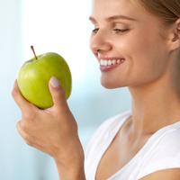 Woman eating green apple