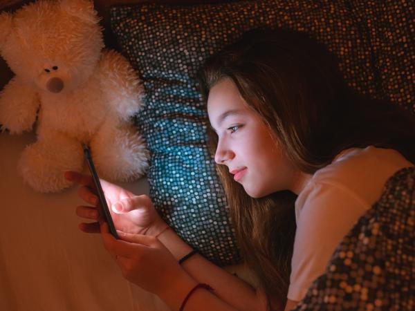 Teenager using smartphone in bed