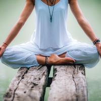 Woman meditating by lake