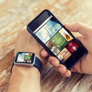 A seamless blend of technology, this image captures a person using a smartphone while wearing a smartwatch. The interaction highlights the convenience and connectivity that modern devices offer in our daily lives.
