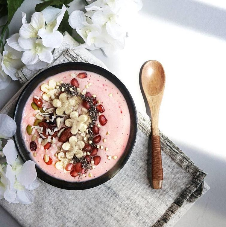 Pink bowl with nut mix breakfast under morning sunlight