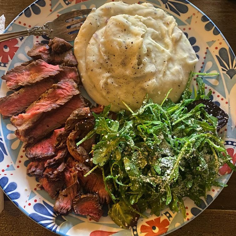 Steak with mashed potatoes and arugula salad