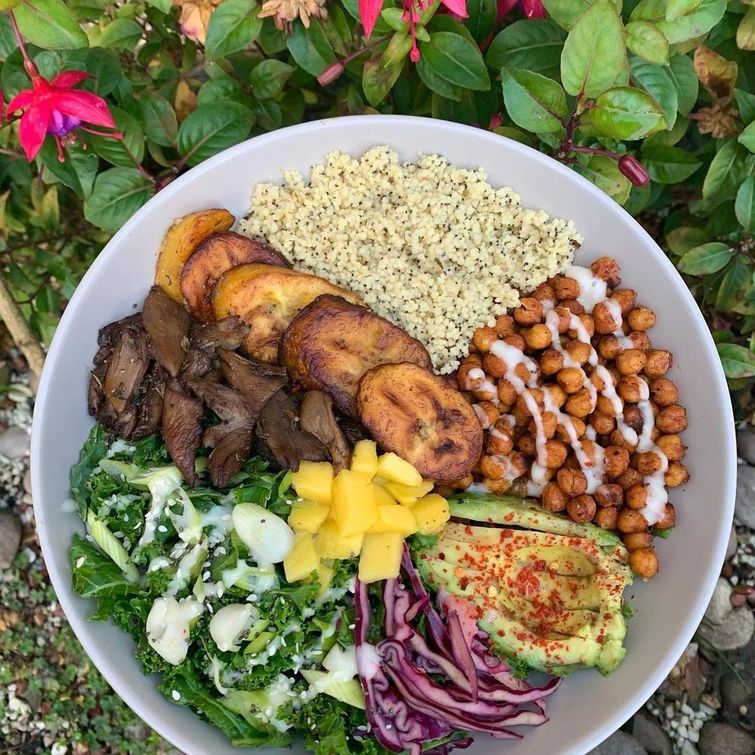 Caribbean inspired veggie bowl with cous cous, chickpeas, plantain, salad, and mushrooms