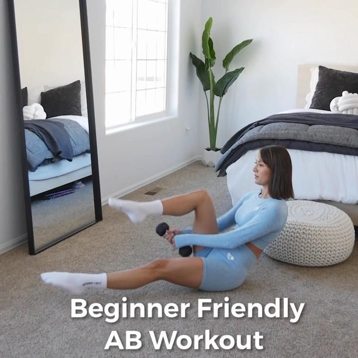 Woman performing ab workout with dumbbell